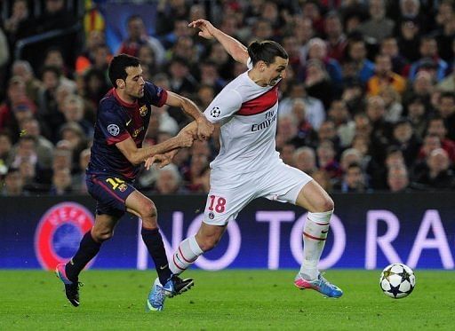 Barcelona's Sergio Busquets (L) vies with PSG's Zlatan Ibrahimovic in Barcelona on April 10, 2013